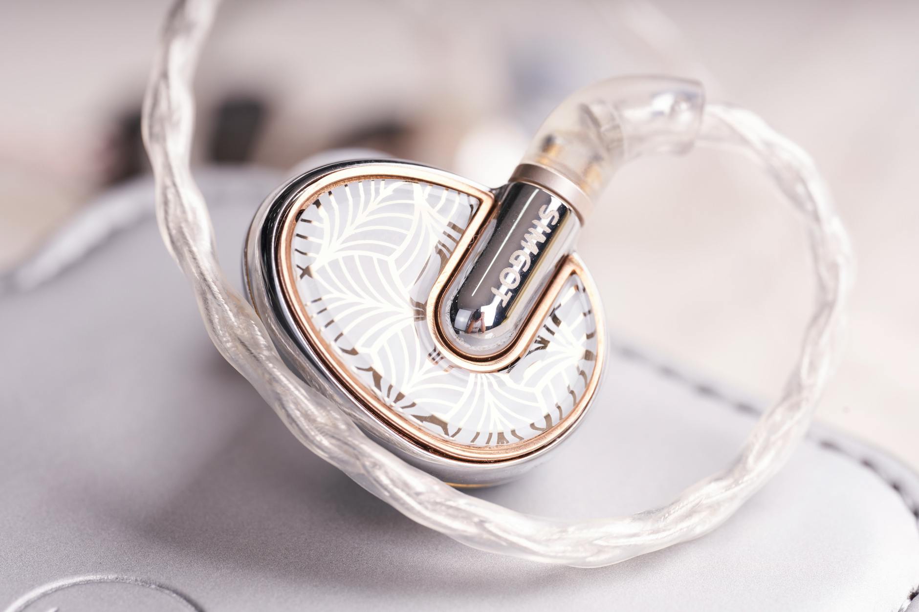 Close-up of stylish in-ear headphones featuring a delicate artistic pattern, perfect for music lovers.
