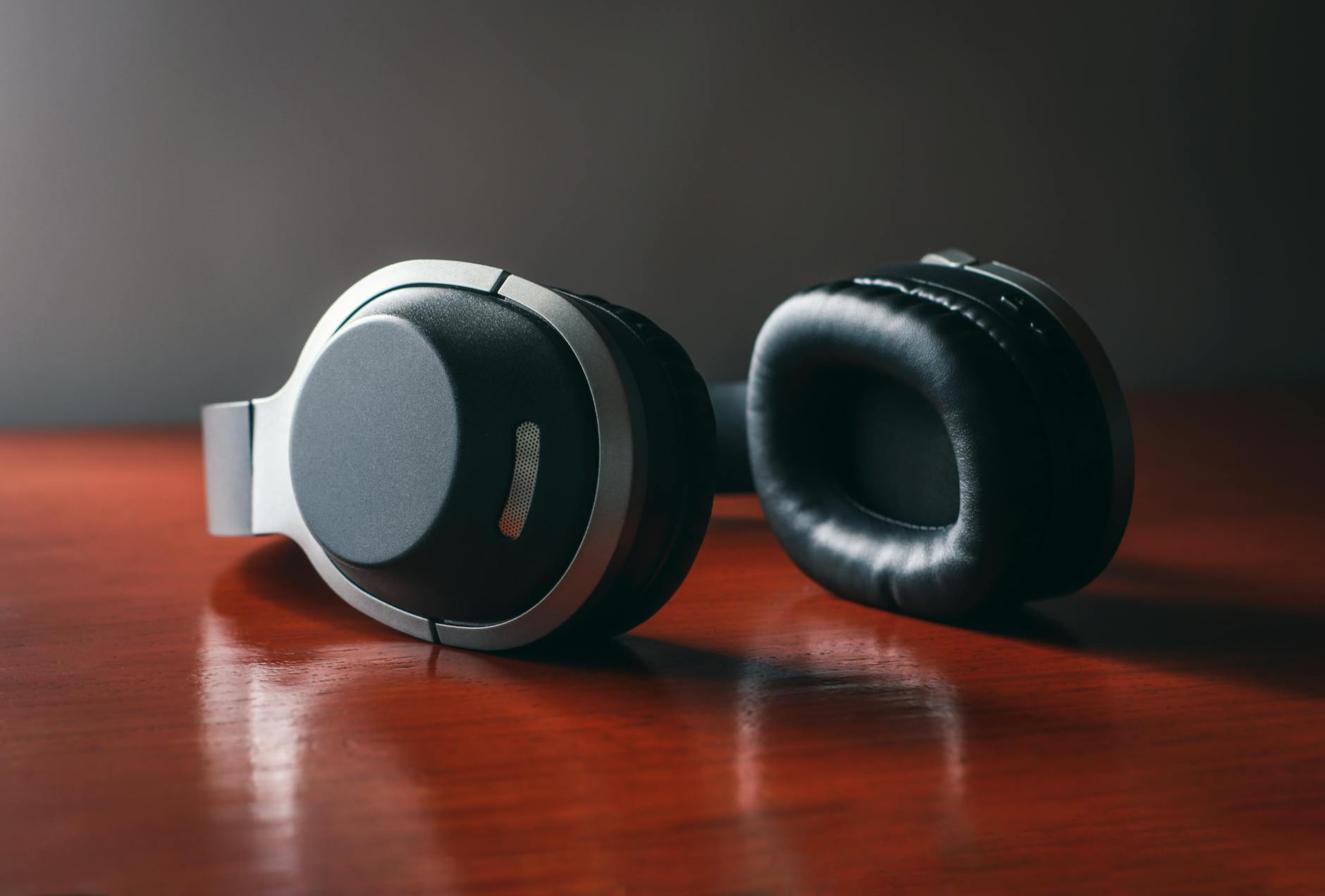 Close-up of wireless headphones placed on a wooden surface, perfect for tech and lifestyle themes.